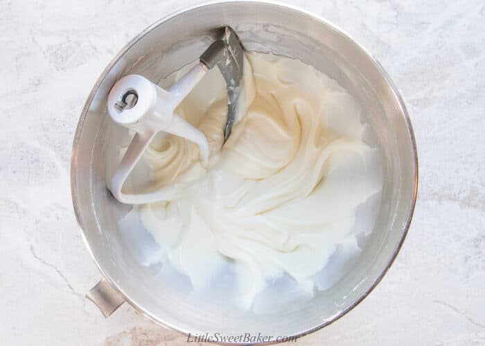 A mixing bowl of cream cheese with paddle attachment.