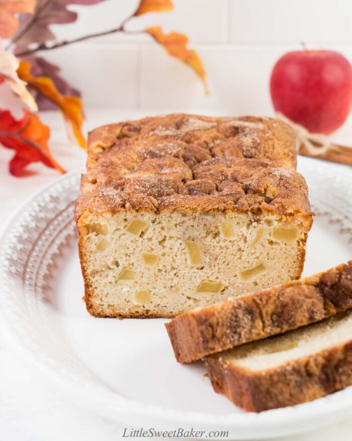 A loaf of apple bread on a white serving plate.