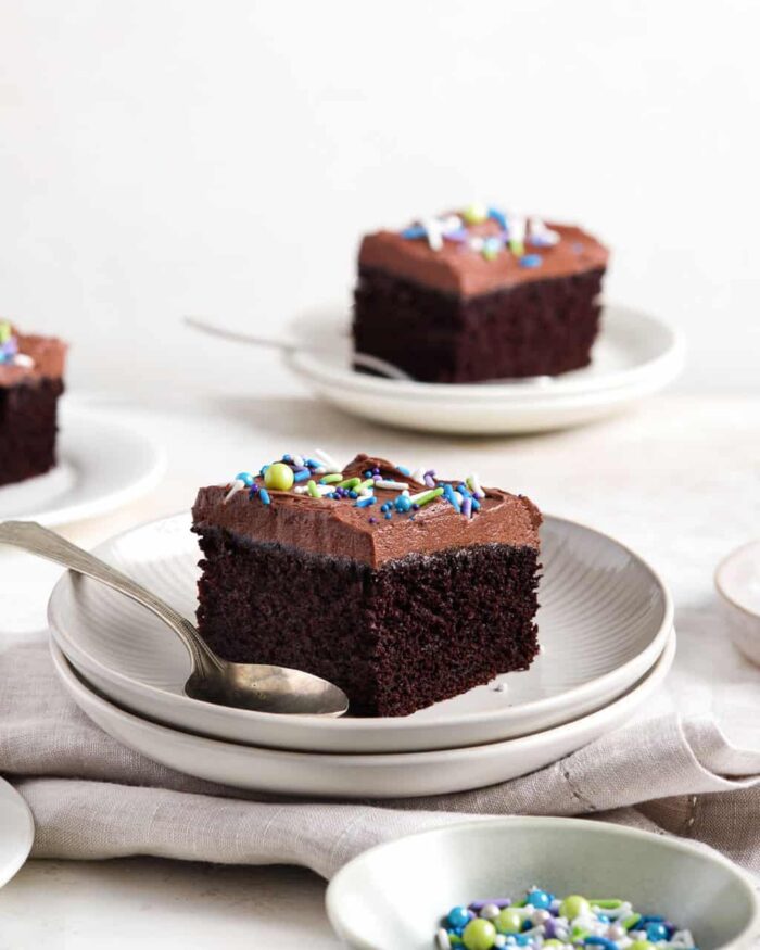 Slices of chocolate sheet cake on white plates