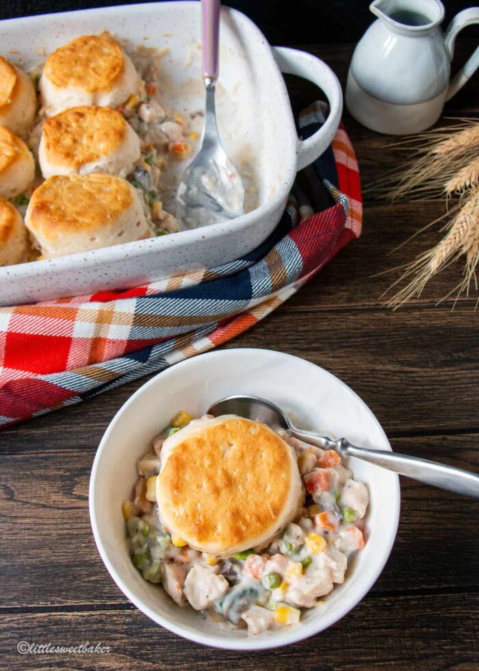 A bowl of turkey and biscuit casserole with the rest of the casserole dish behind