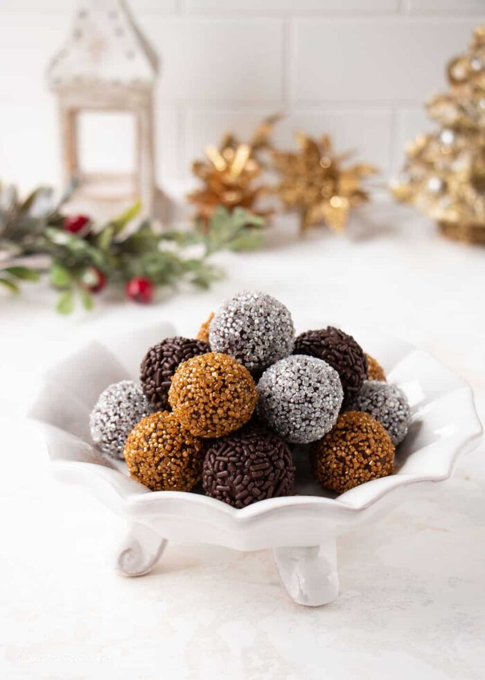 A small white candy bowl filled with homemade chocolate truffles