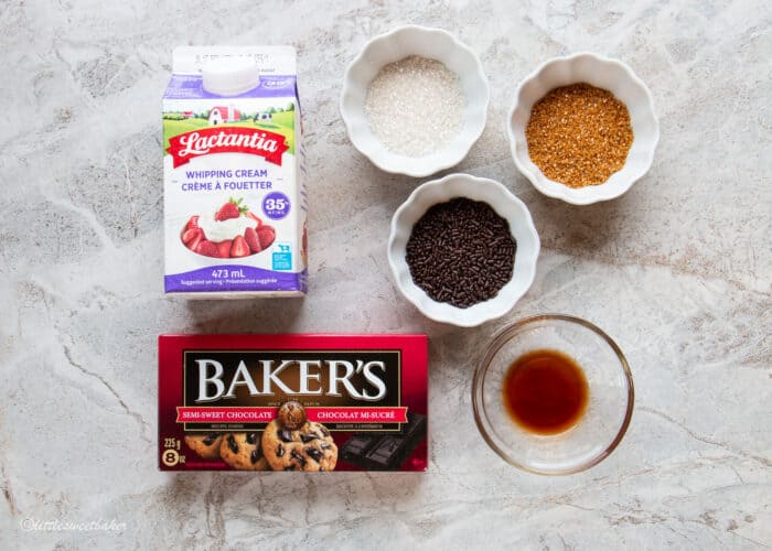 Image of ingredients to make chocolate truffles, baking chocolate, whipping cream, vanilla and sprinkles.