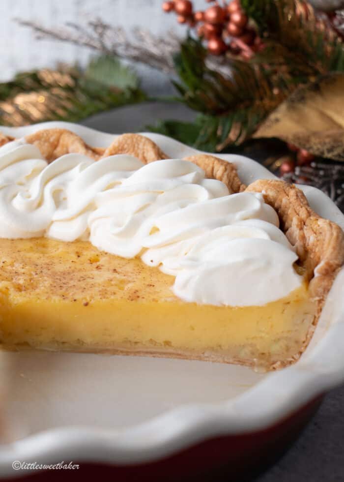 An eggnog pie in a pie plate with a slice missing.