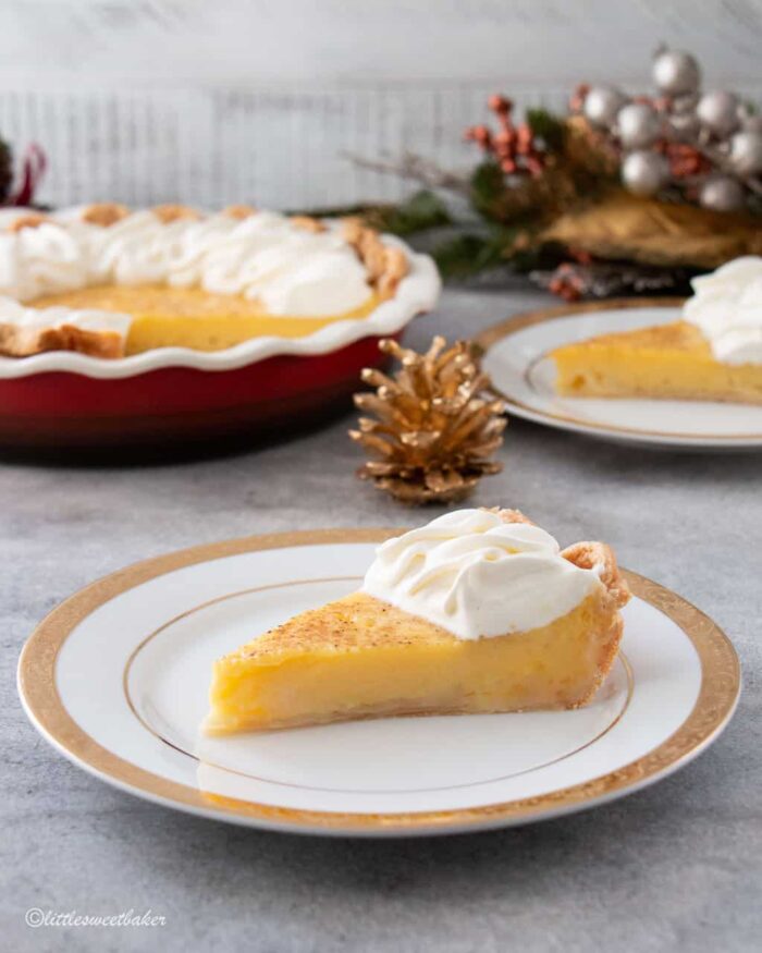 A slice of eggnog pie with whipped cream on a gold trimmed plate.
