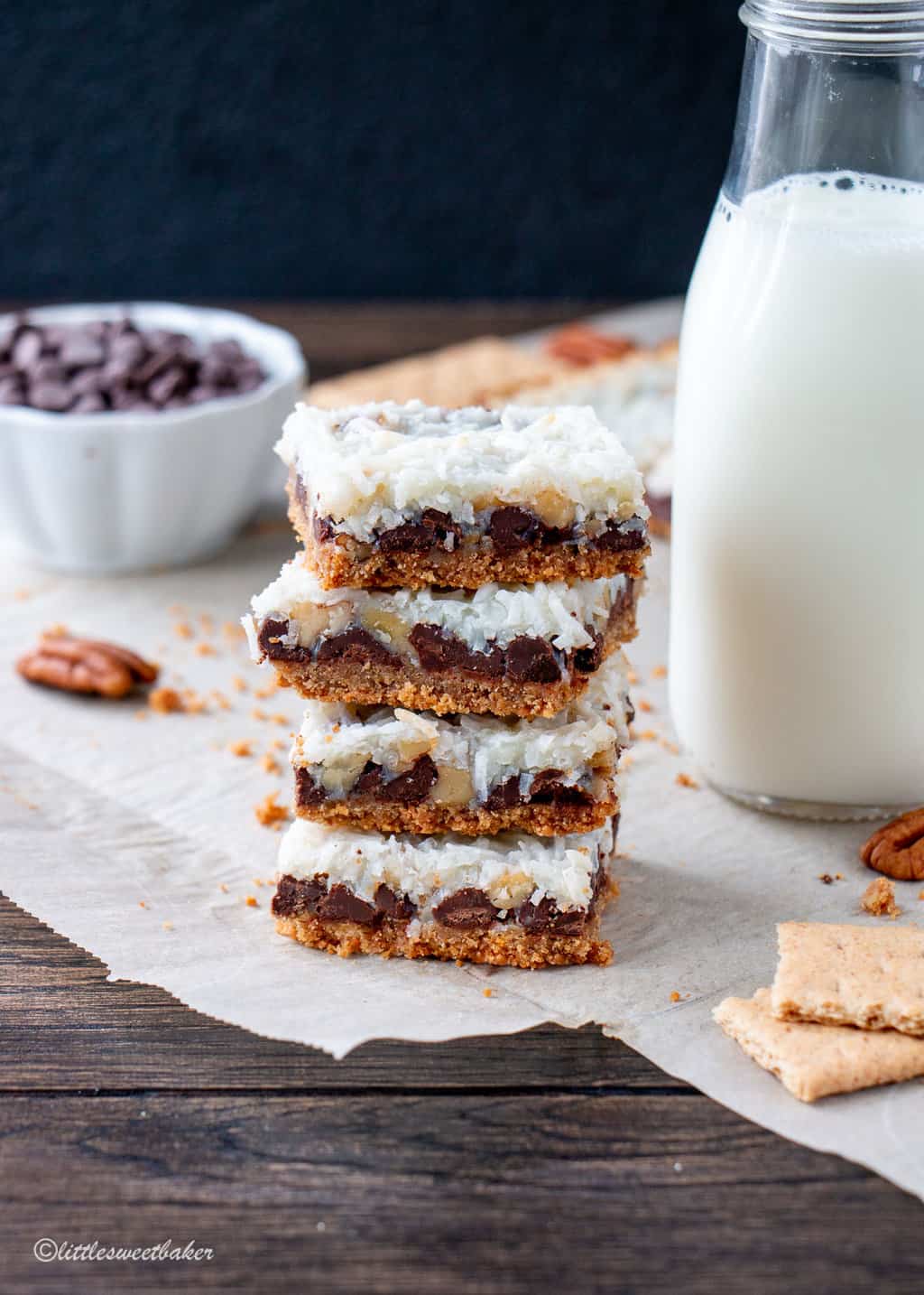 A stack of hello dolly bars with a glass of milk beside