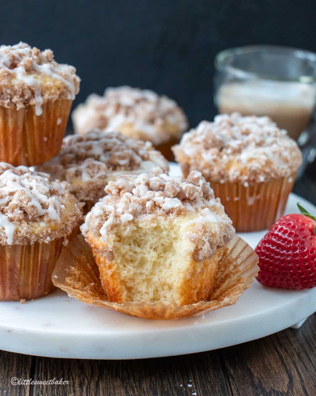 coffee cake muffins in a white marble board with a bite taken out of one
