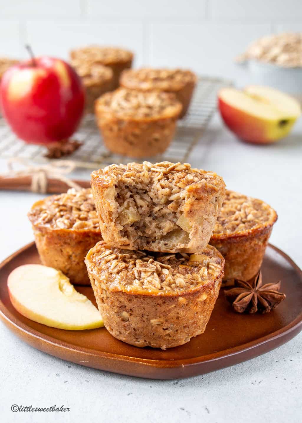 Baked apple oatmeal cups on a plate with a bite taken out of the top one