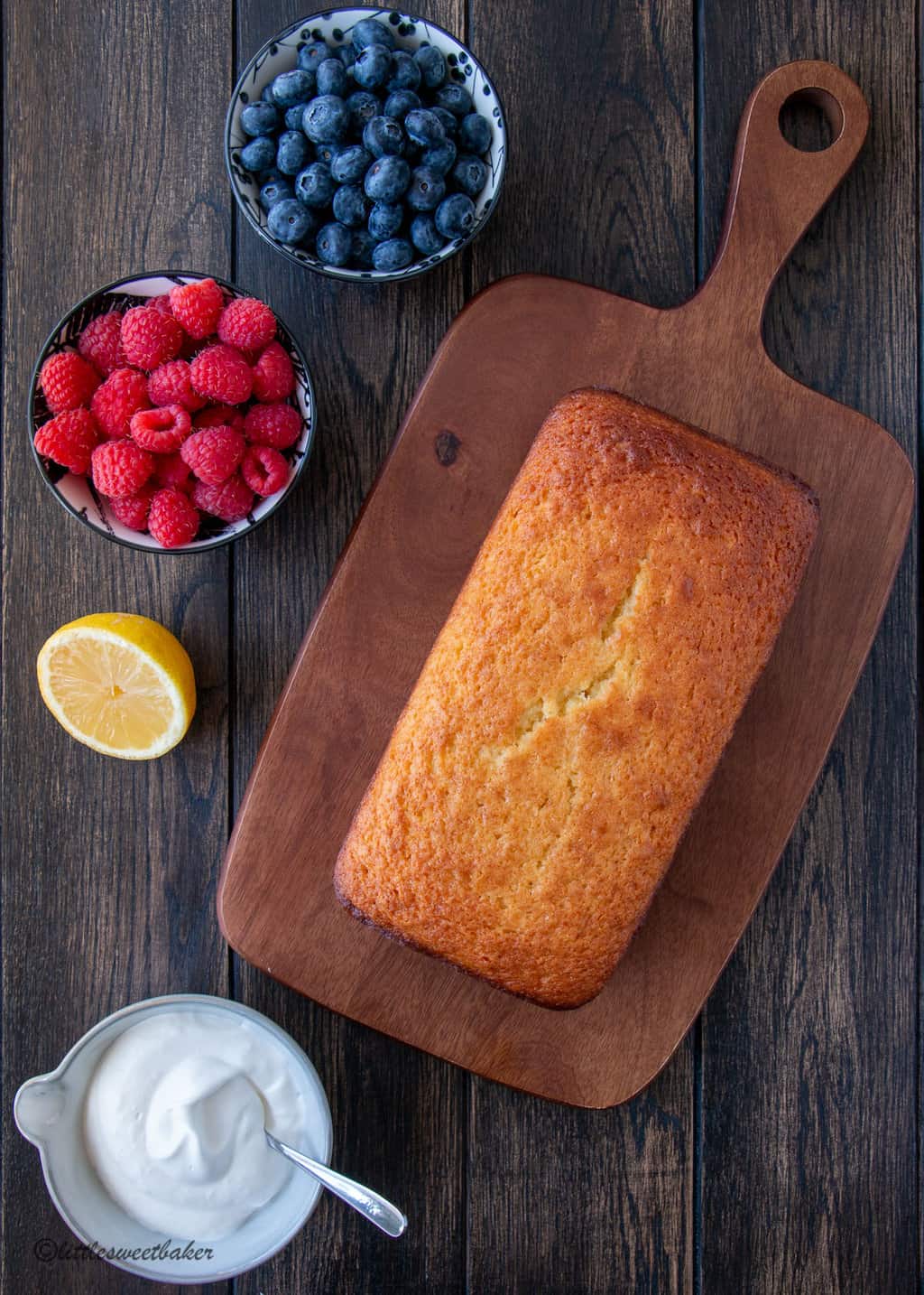 A loaf of French yogurt cake on a wooden cutting board.