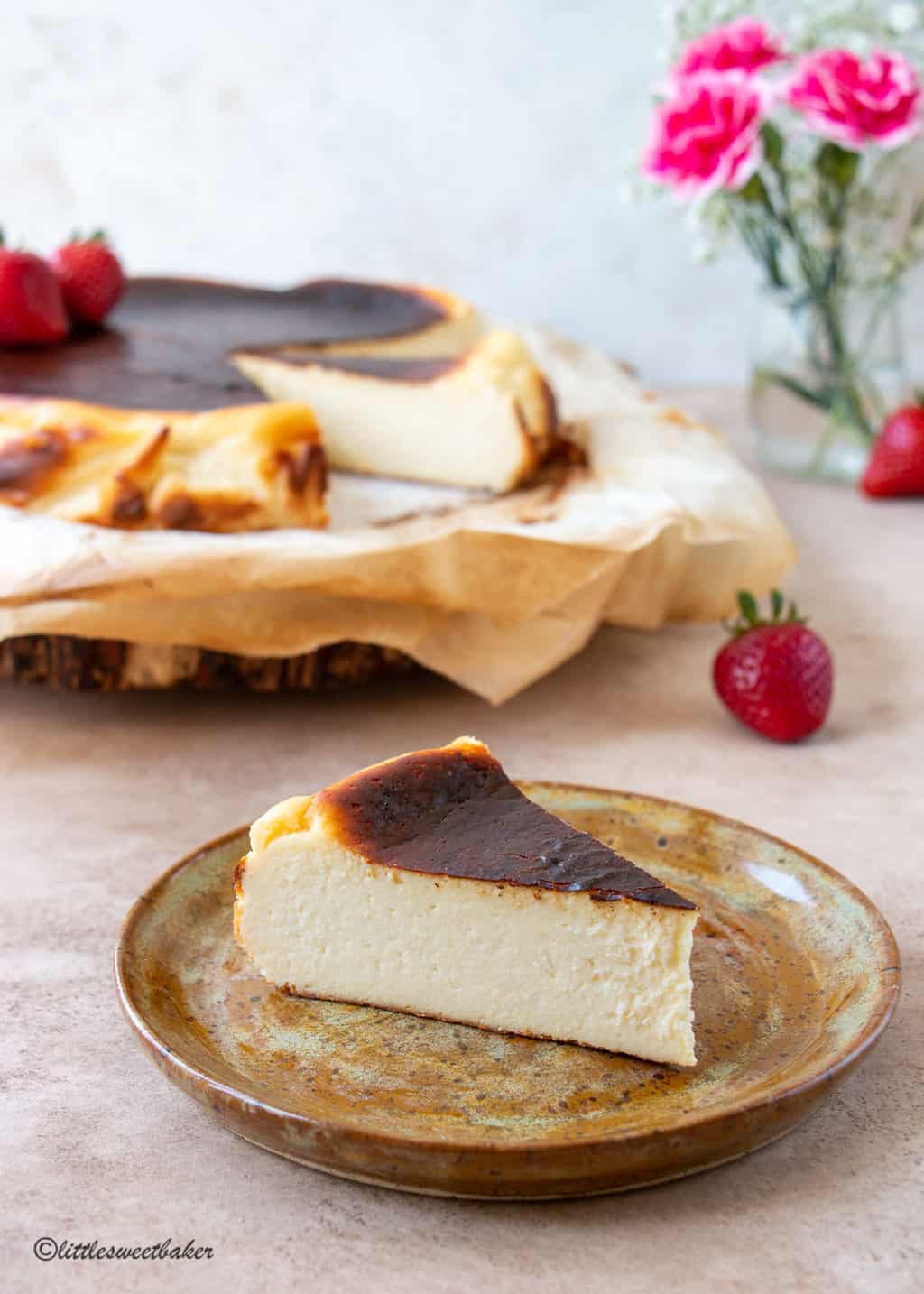 A slice of basque cheesecake of a brown rustic plate
