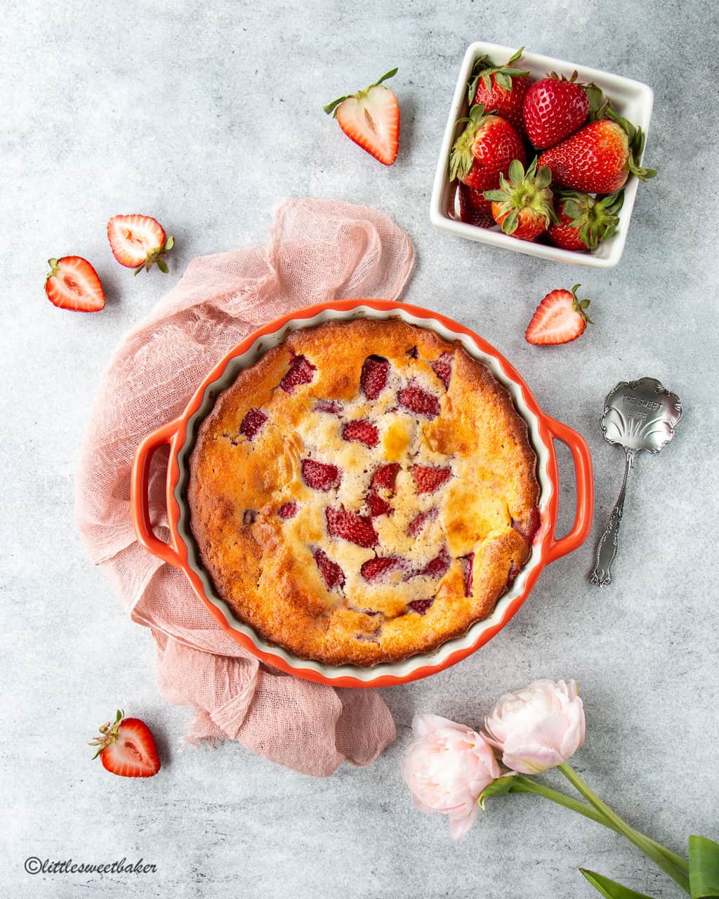 strawberry cobbler in a coral-colored pie plate