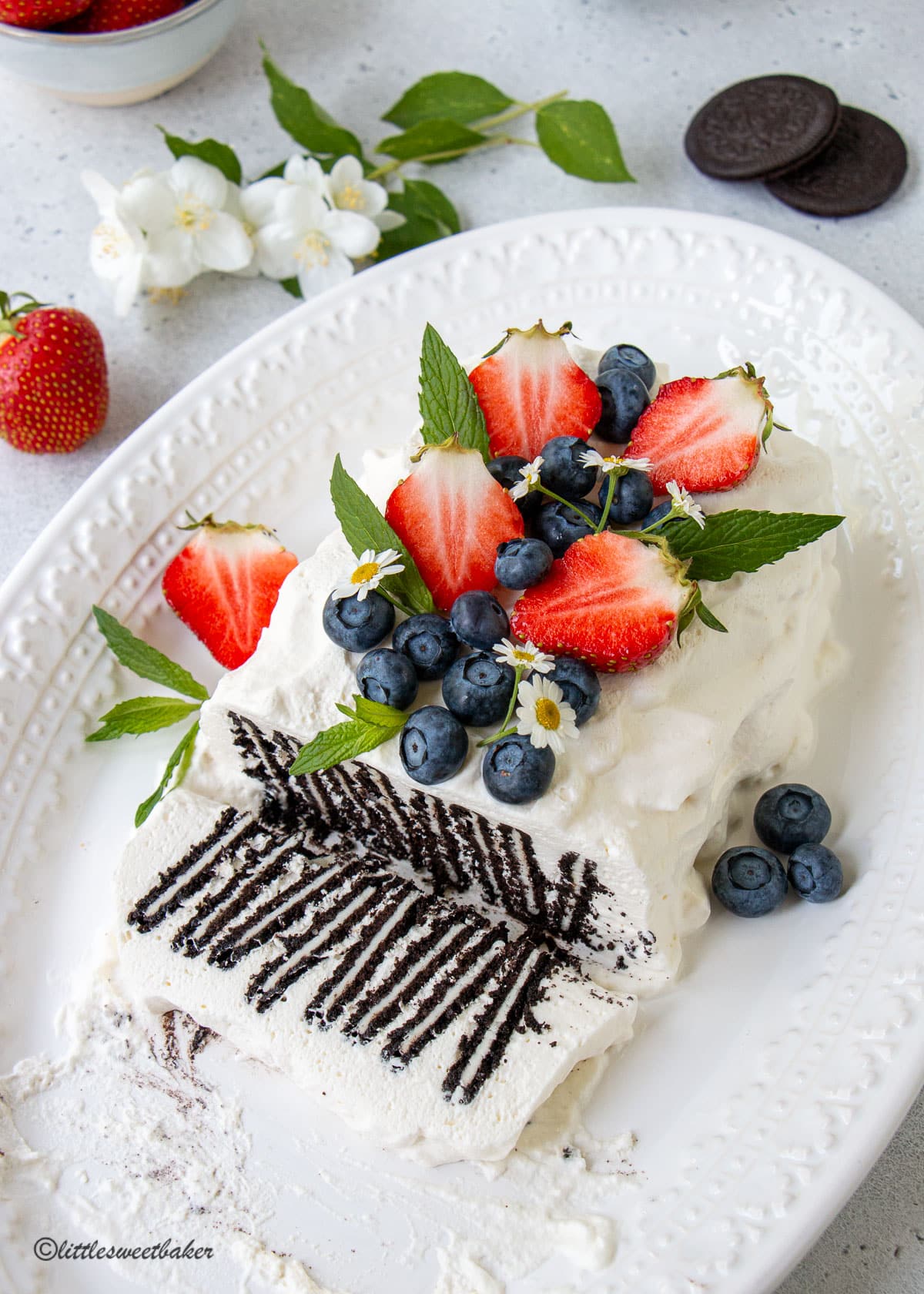Icebox cake made with Oreos topped with strawberries and blueberries.