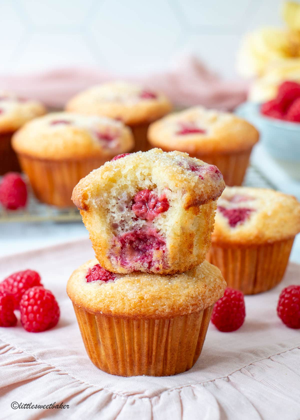 Two muffins stacked with a bite taken out of the top one.