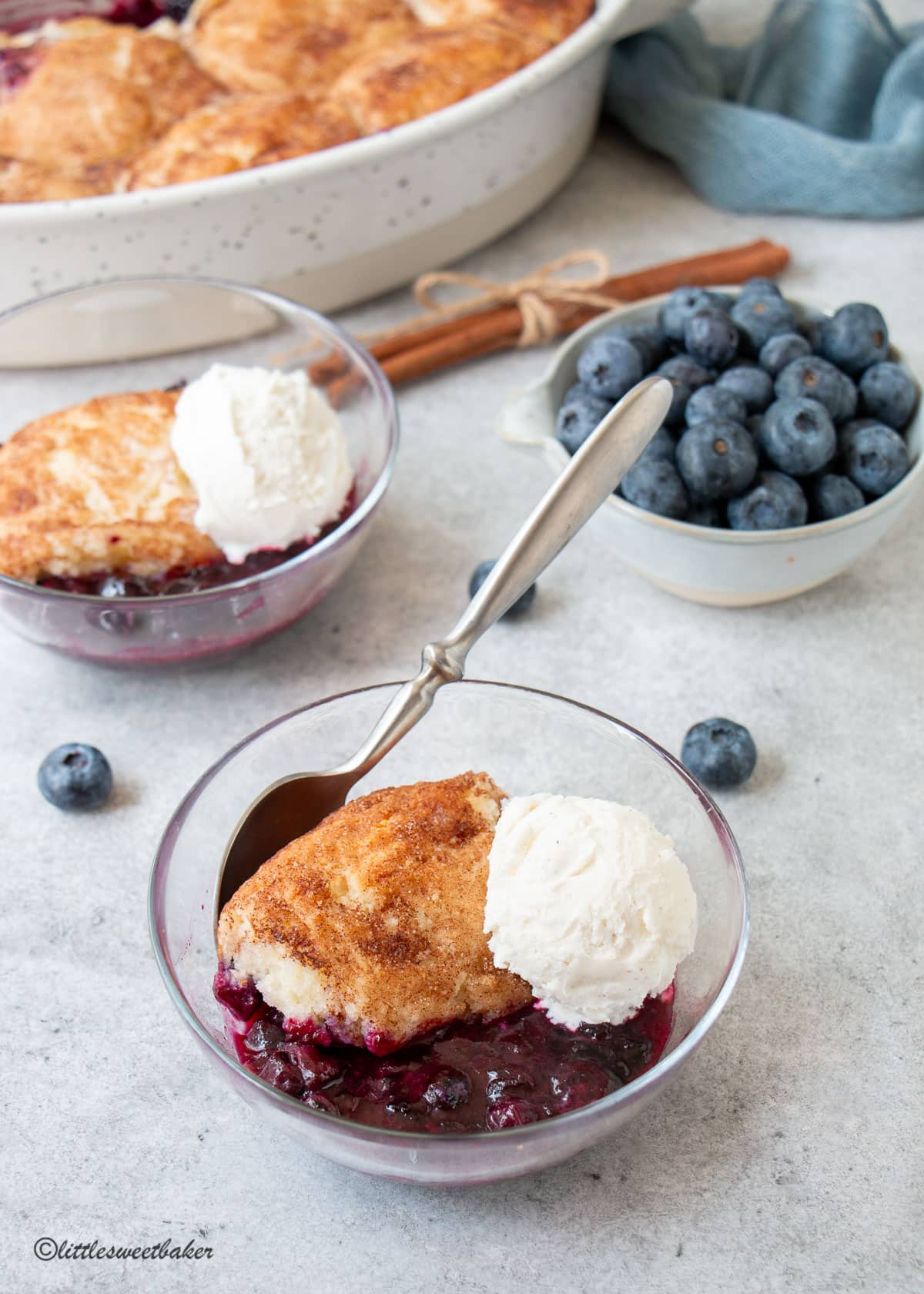 two bowls of blueberry cobbler and a bowl of fresh blueberries