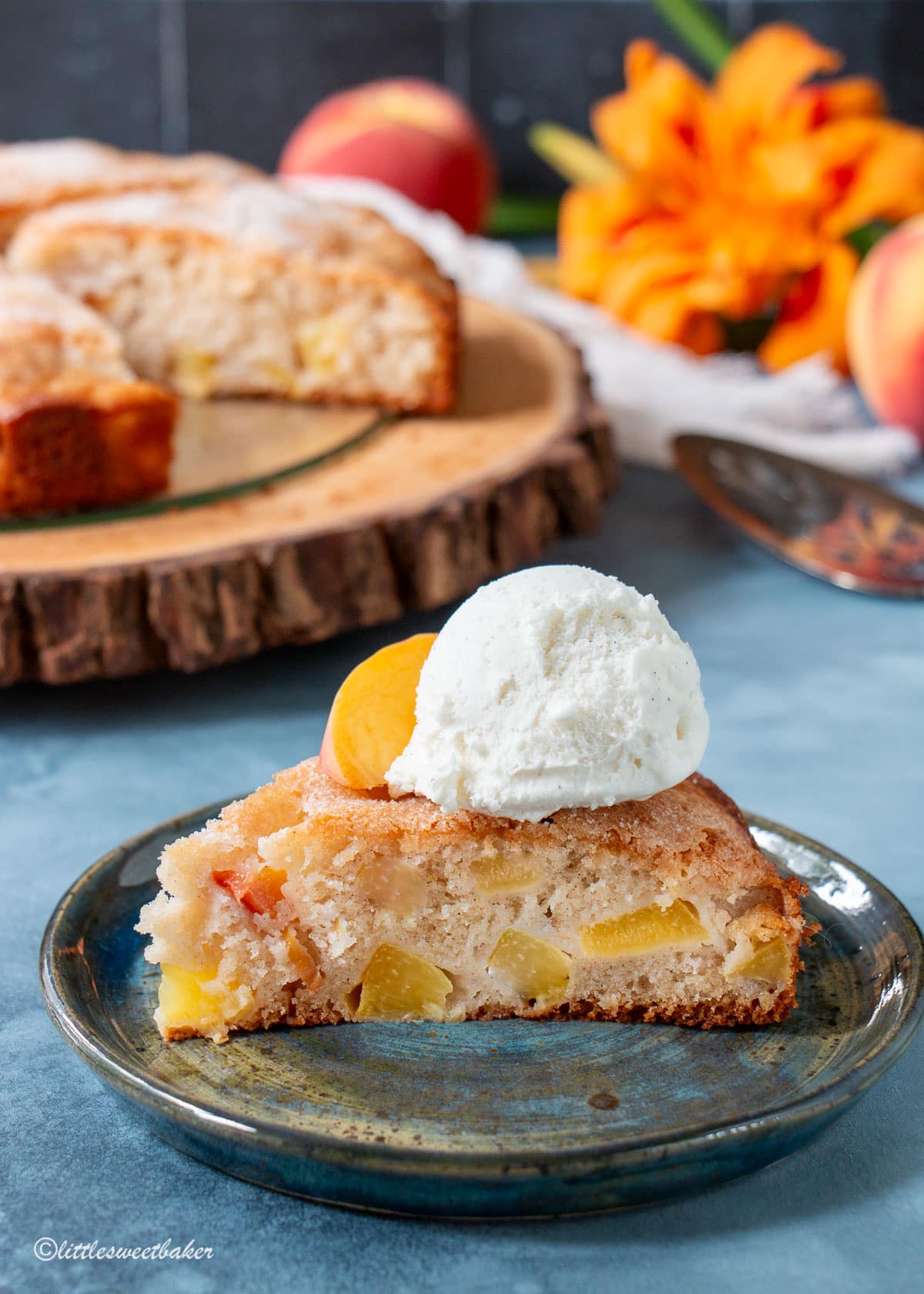 A slice of peach cake topped with ice cream and a peach slice