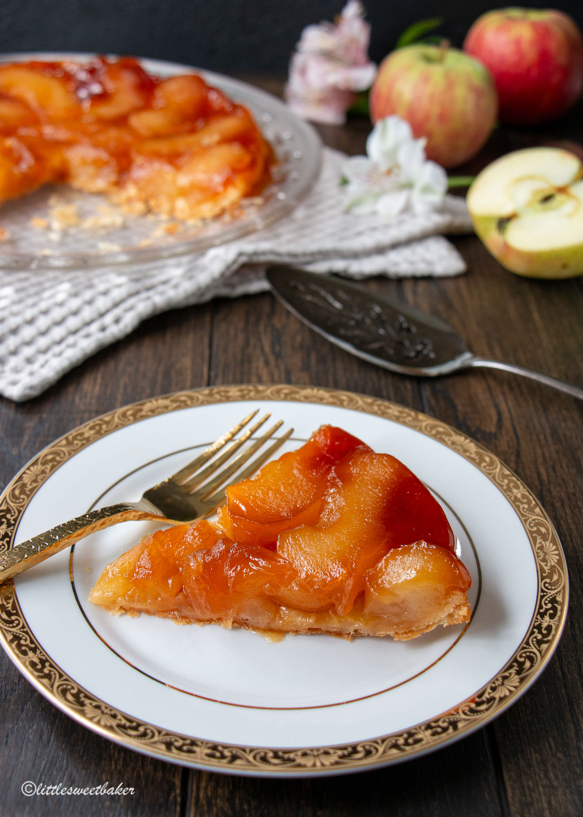 A slice of apple tarte tatin on w white and gold plate.