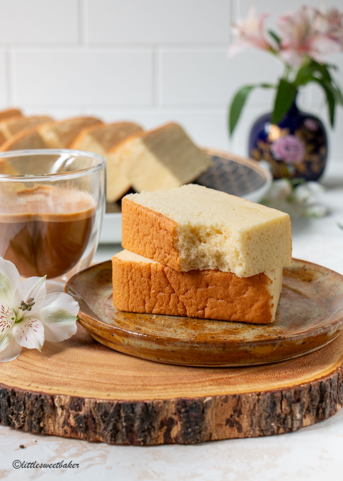 two slices of castella cake on a plate with a cup of coffee