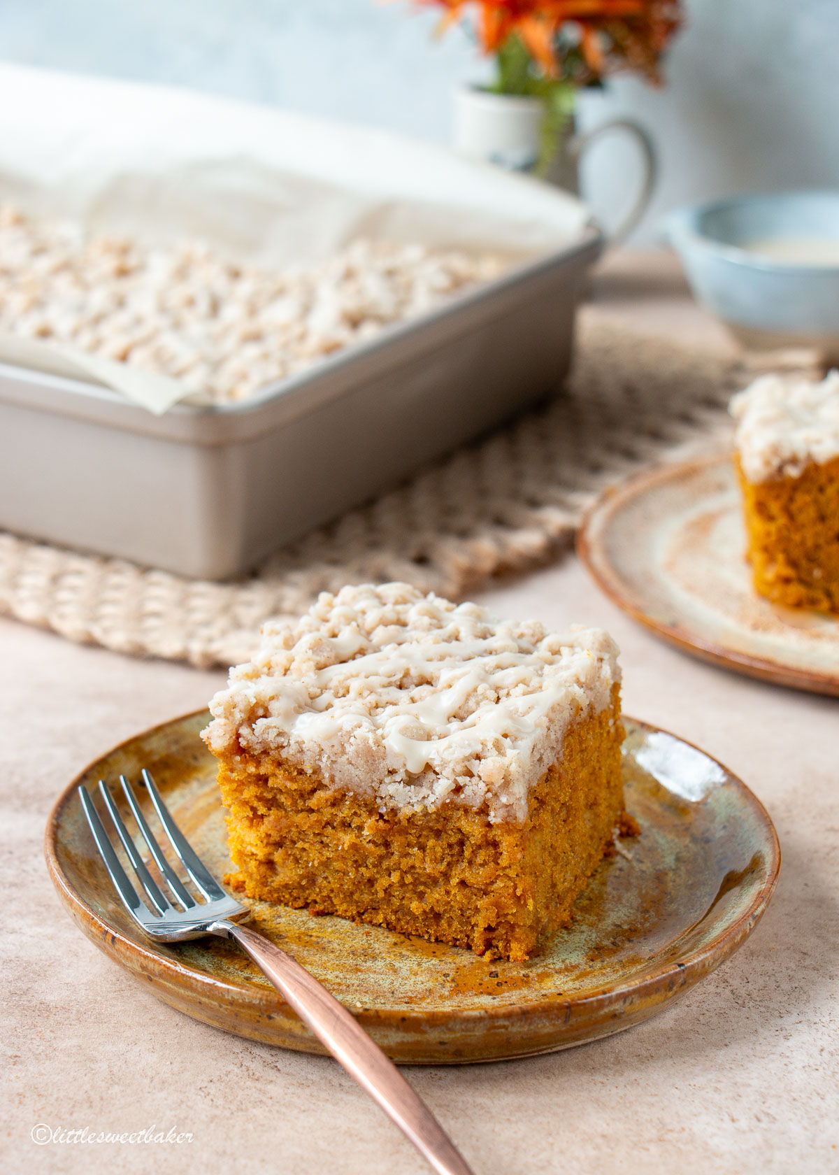 A slice of pumpkin coffee cake on a plate with a fork.