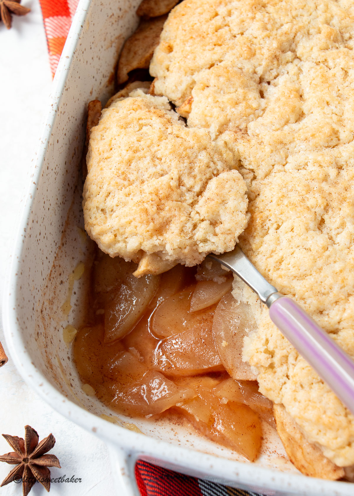 A close up of a dish of apple cobbler showing the apple filling.