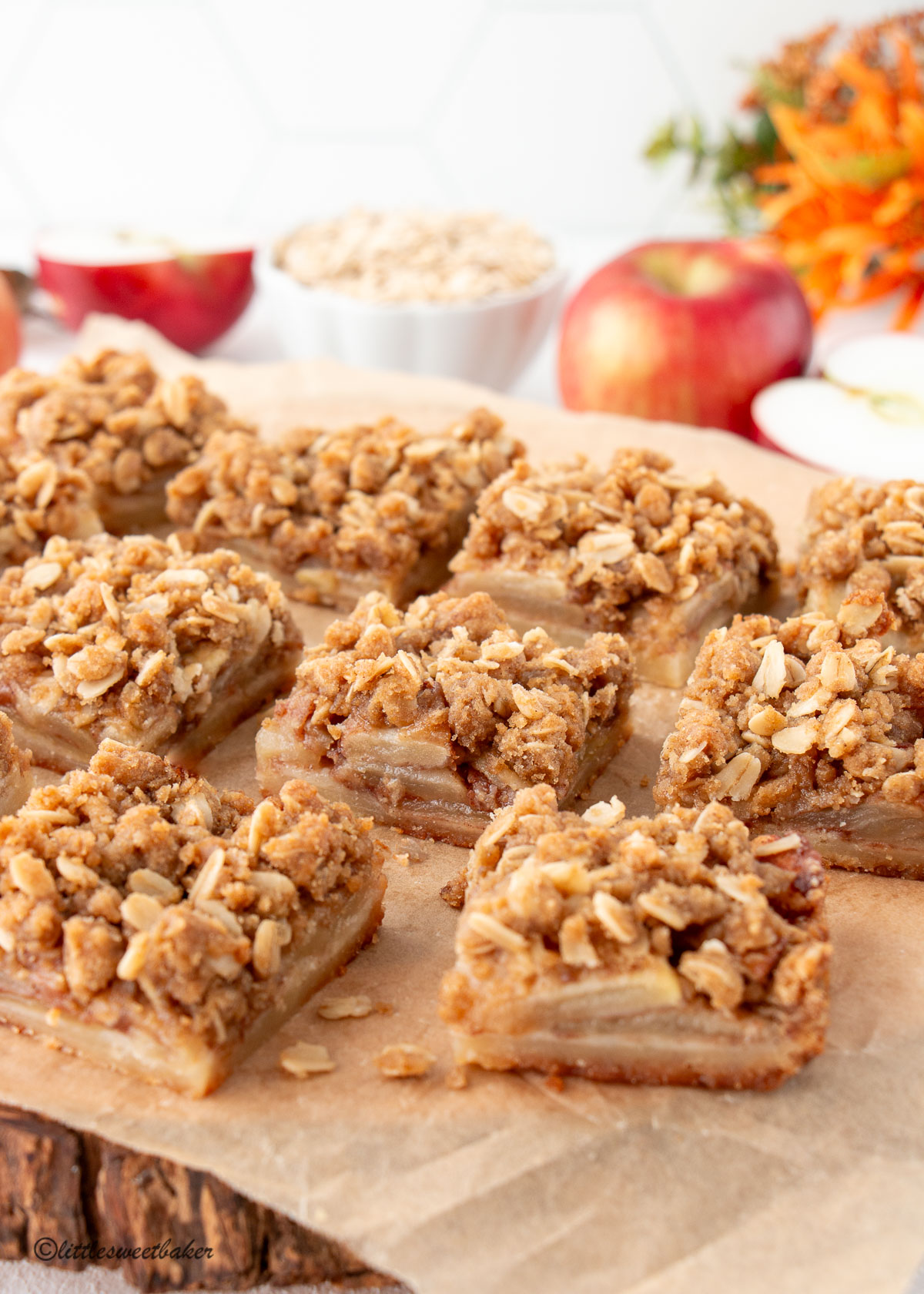 Apple crisp bars on parchment paper and wooden board.