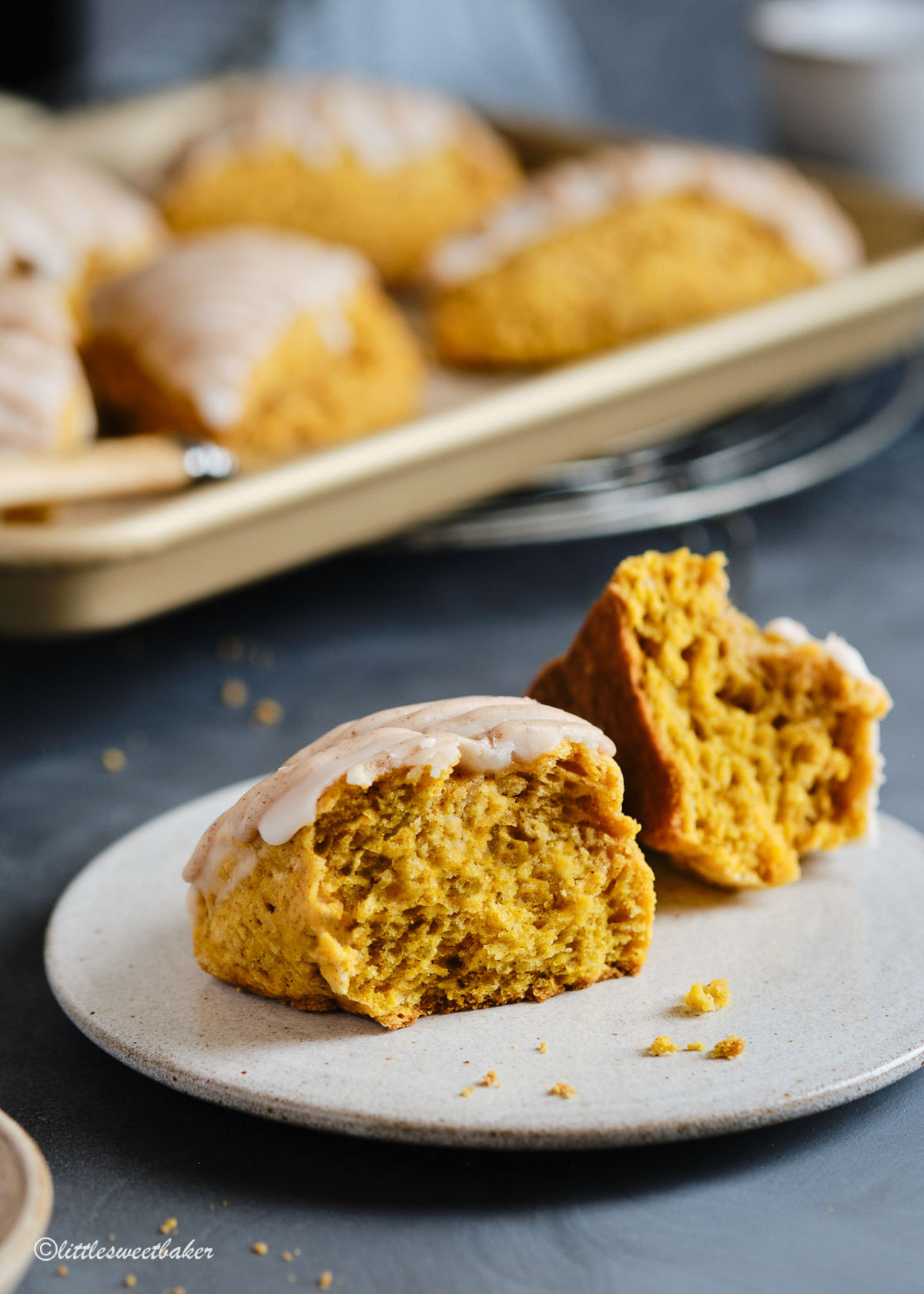 A pumpkin scone broken in half on a plate.