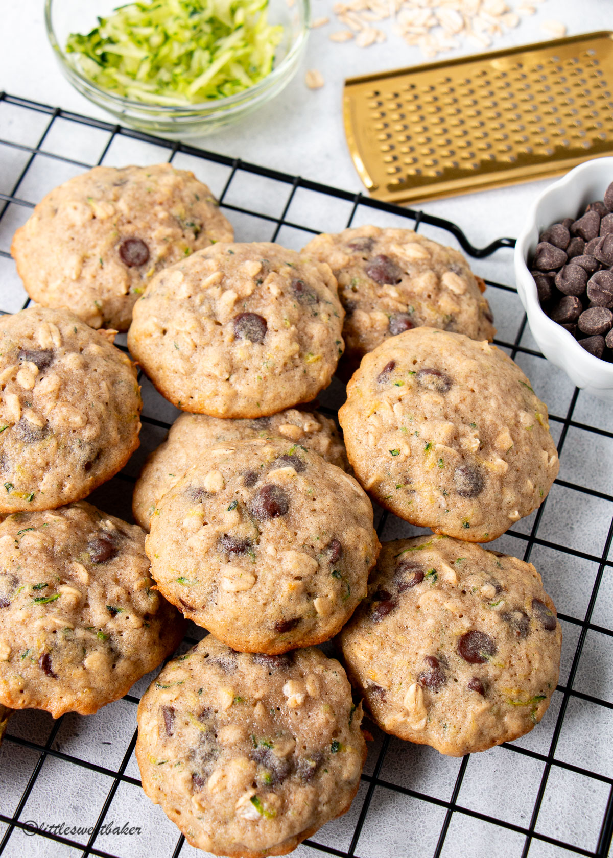 A pile of zucchini oatmeal cookies on a cooling rack.