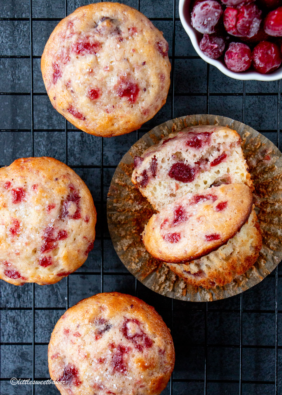 cranberry sauce muffins on a cooling rack with one cut in half