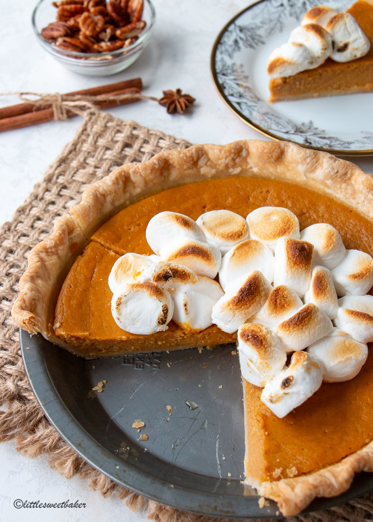 sweet potato pie in a metal pie pan with two slices missing.