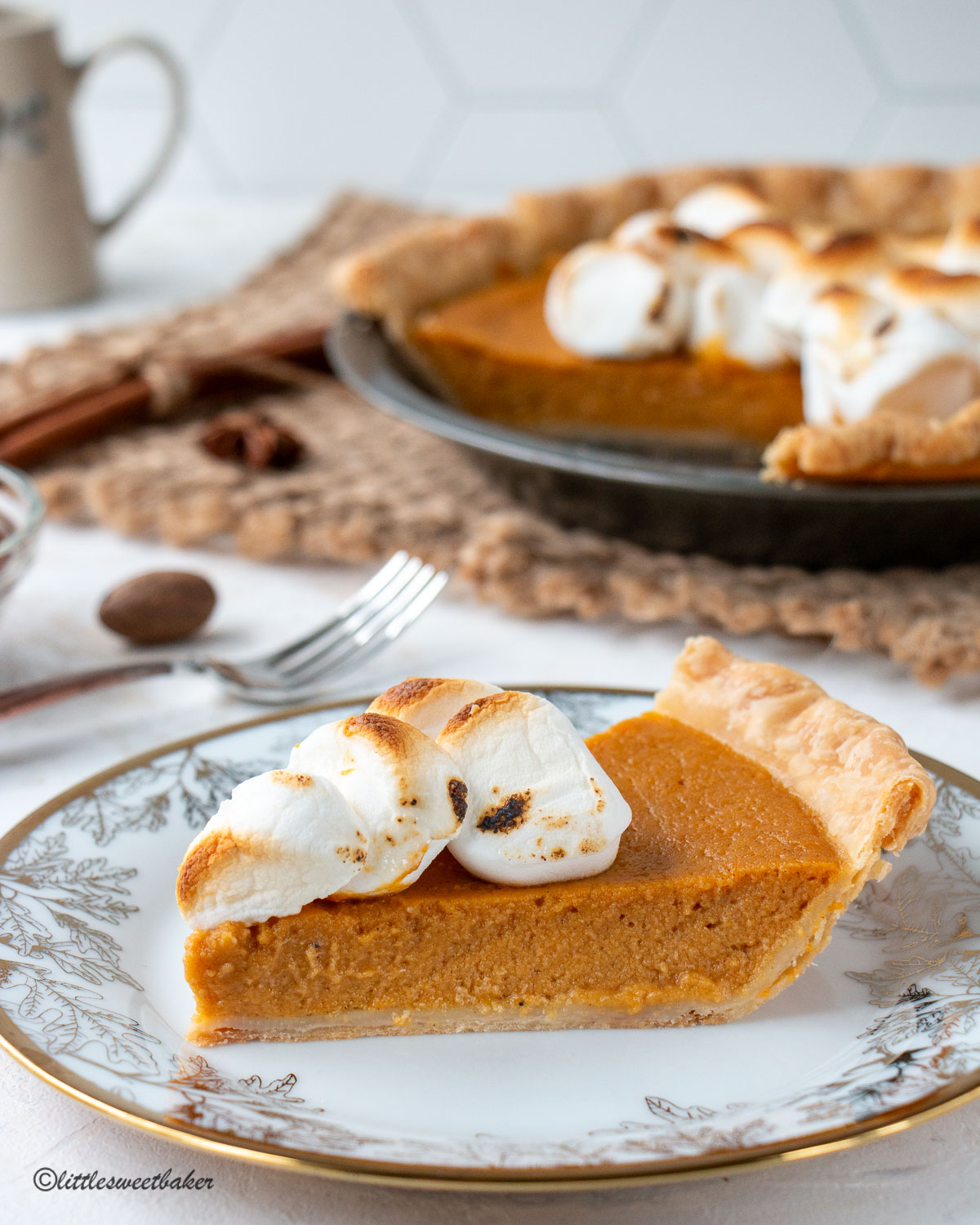 A slice of sweet potato pie on a white and gold plate.