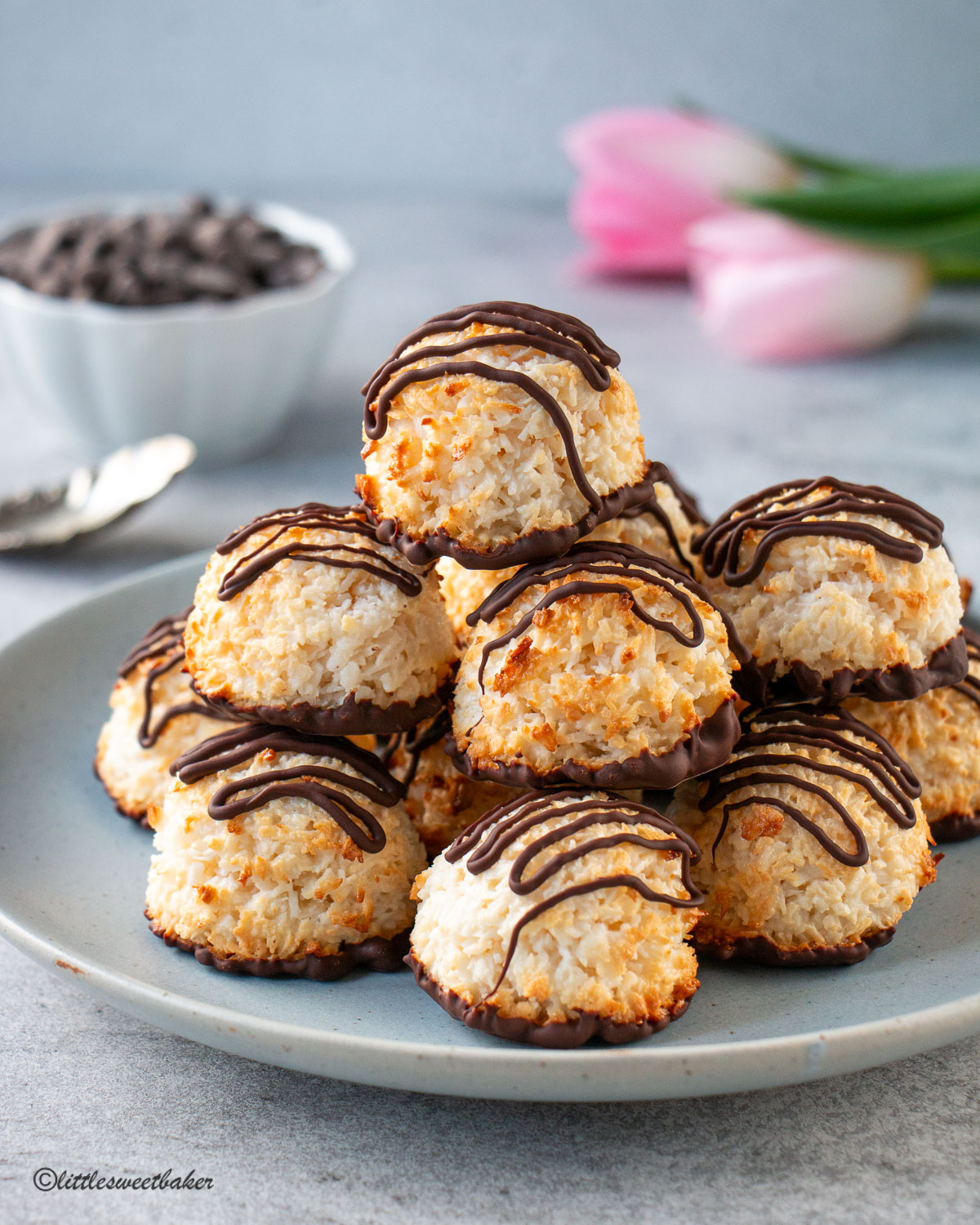Chocolate dipped coconut macaroons piled on a blue plate