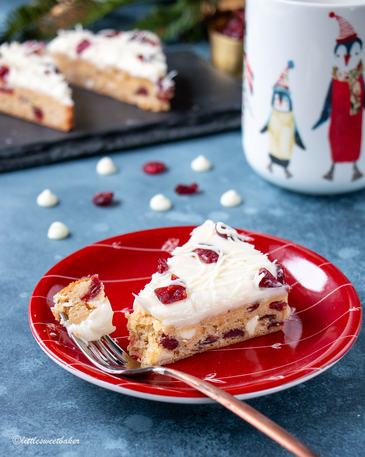 A cranberry bliss bar in a red plate with a piece on a fork.