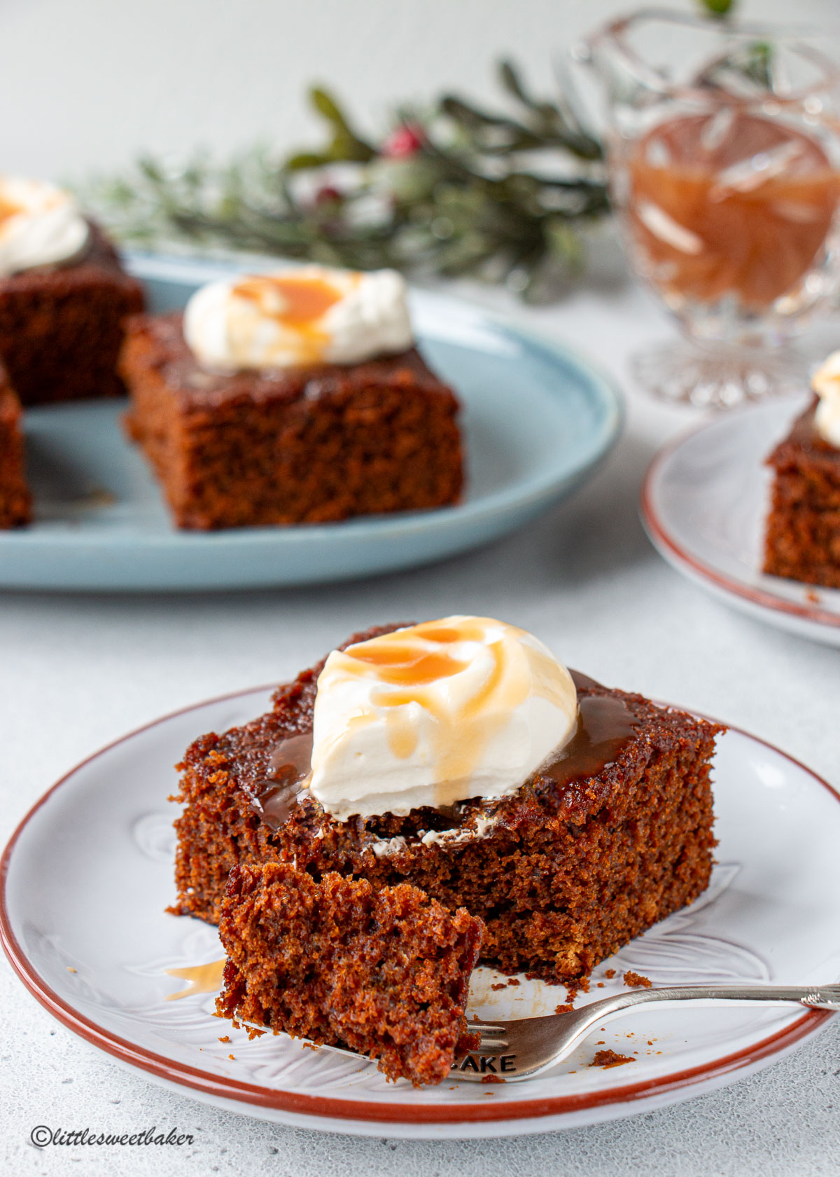 A slice of gingerbread cake on a gray plate with a piece on a fork.