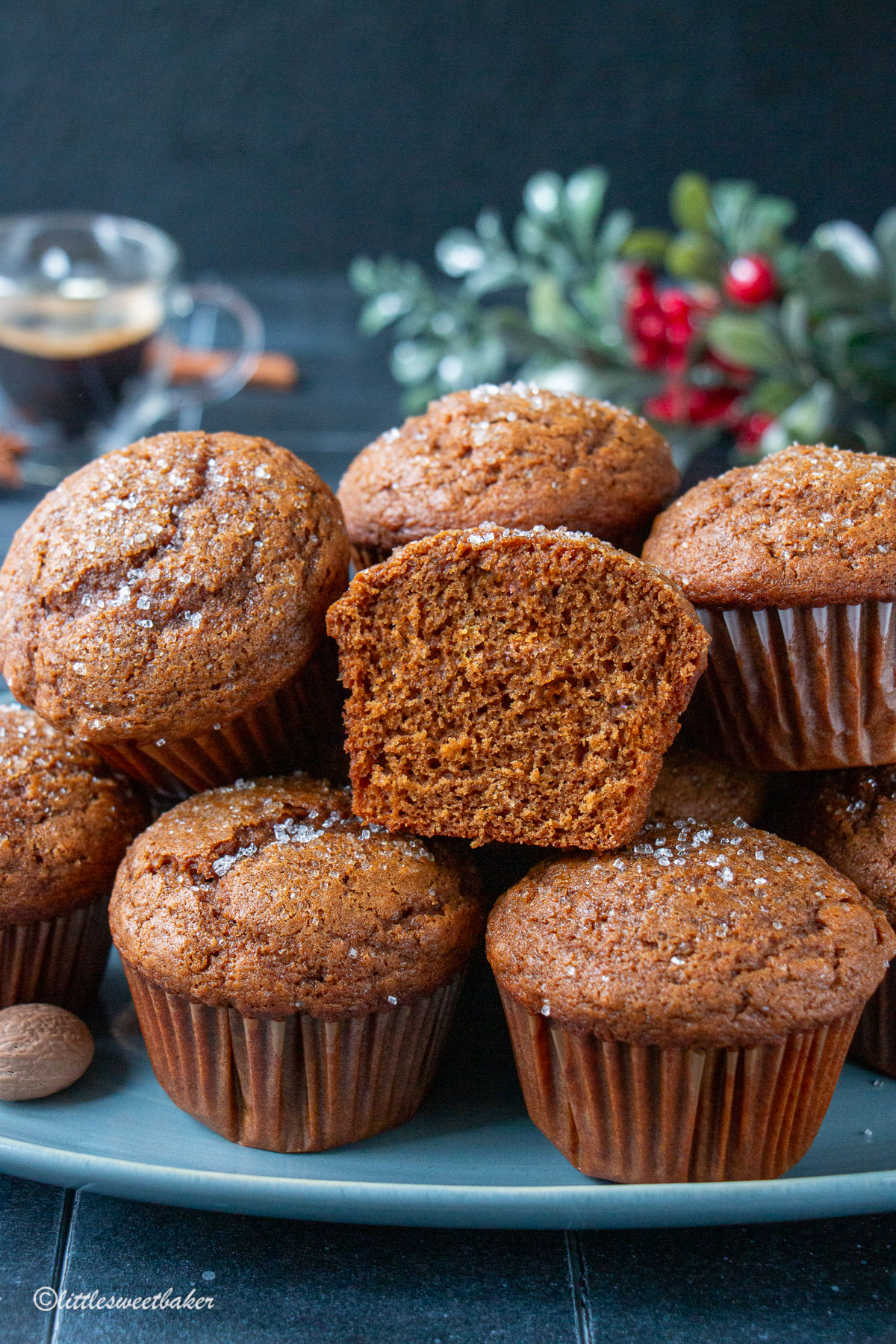 Gingerbread muffins piled on a blue plate with one cut in half.