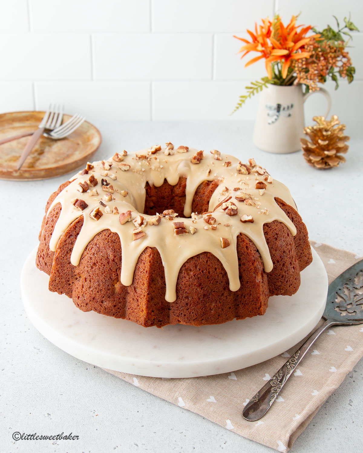 A sweet potato cake with brown sugar glaze on a marble cake plate