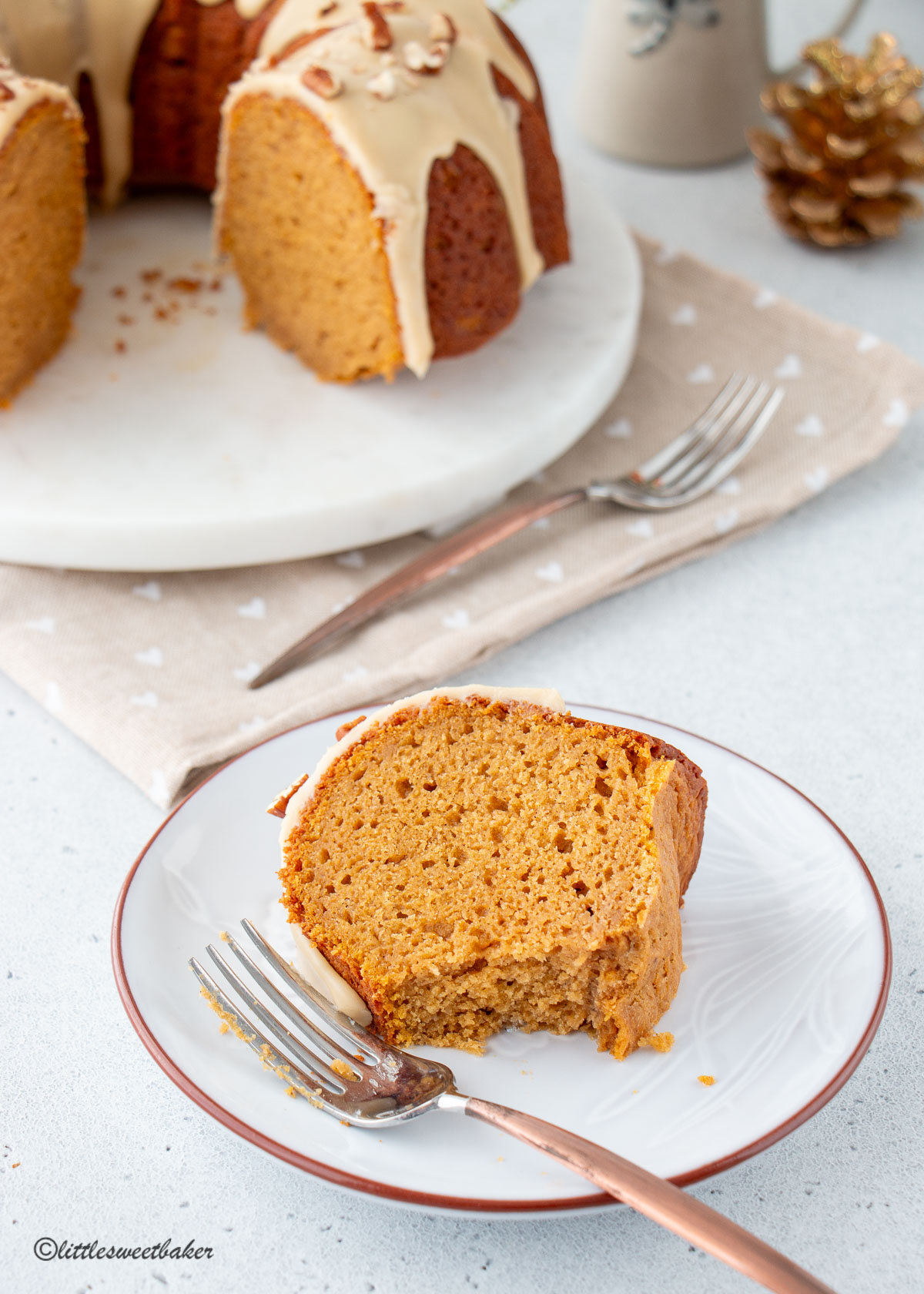 A slice of sweet potato bundt cake on a plate with a fork and piece missing.