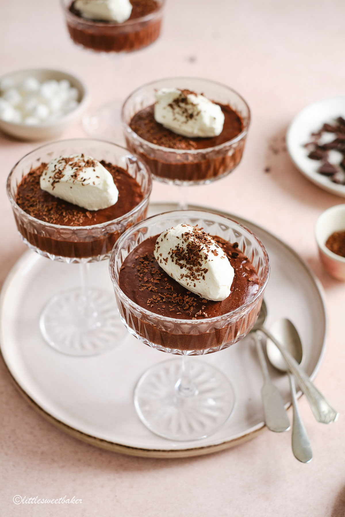 Three champagne glasses of chocolate mousse on a plate.