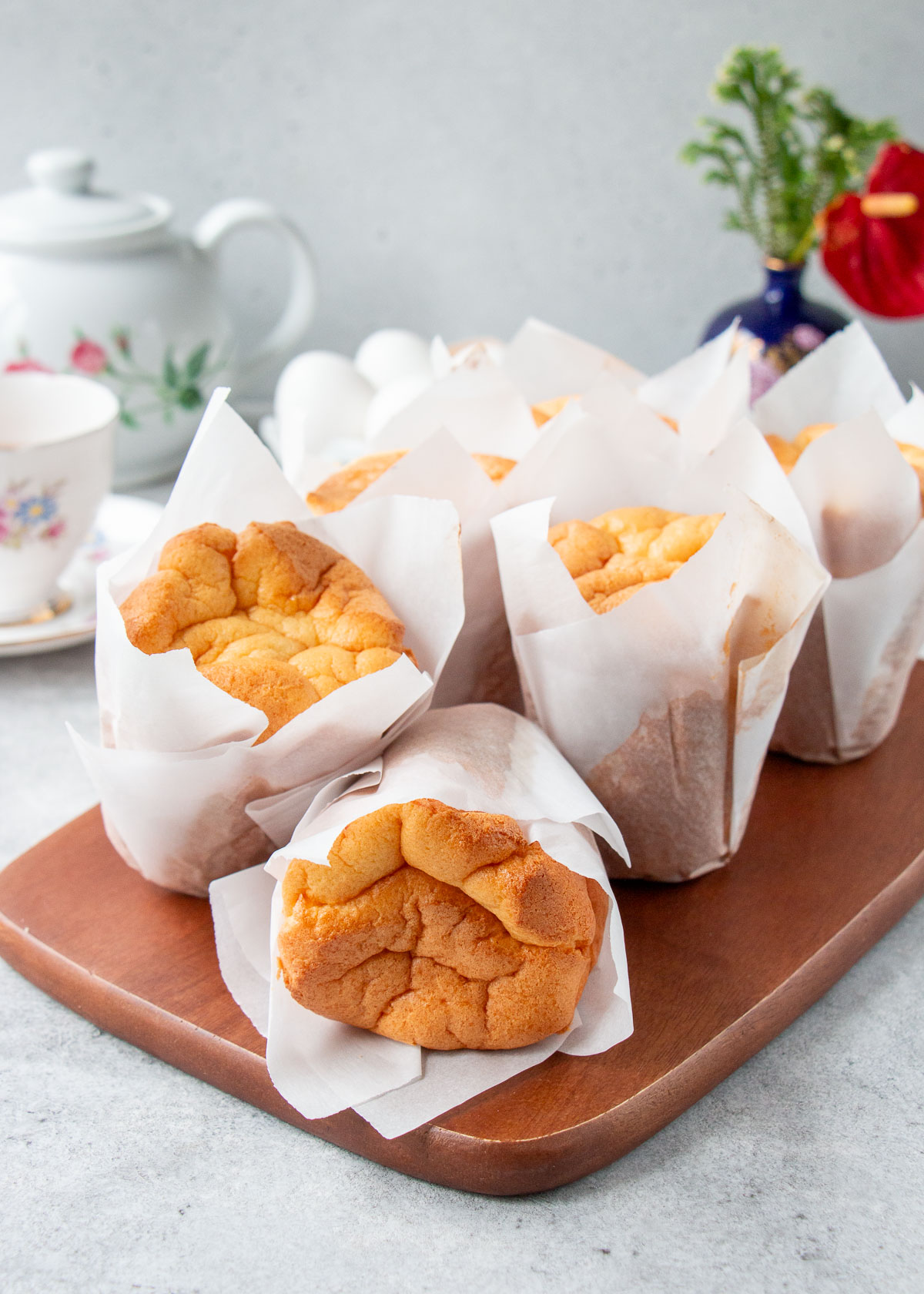 Chinese paper-wrapped sponge cakes on a wooden board.