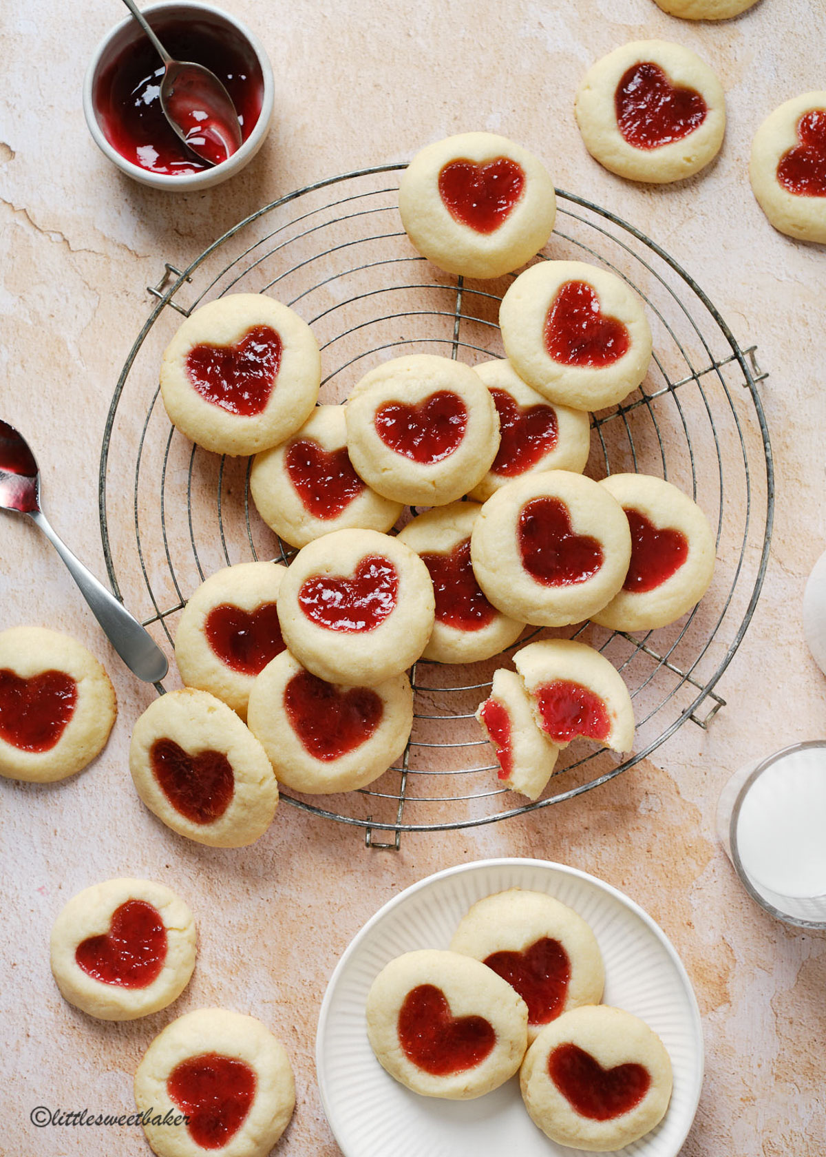 Strawberry thumbprint cookies scattered on a cooling rack