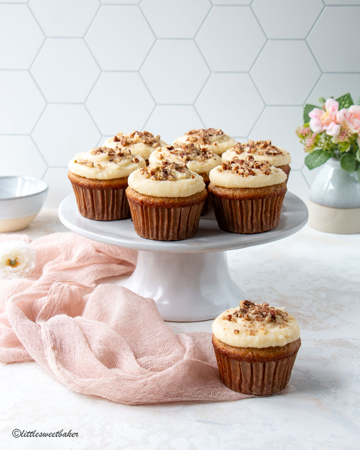 carrot cake cupcakes on a cake stand  with a pink linen napkin