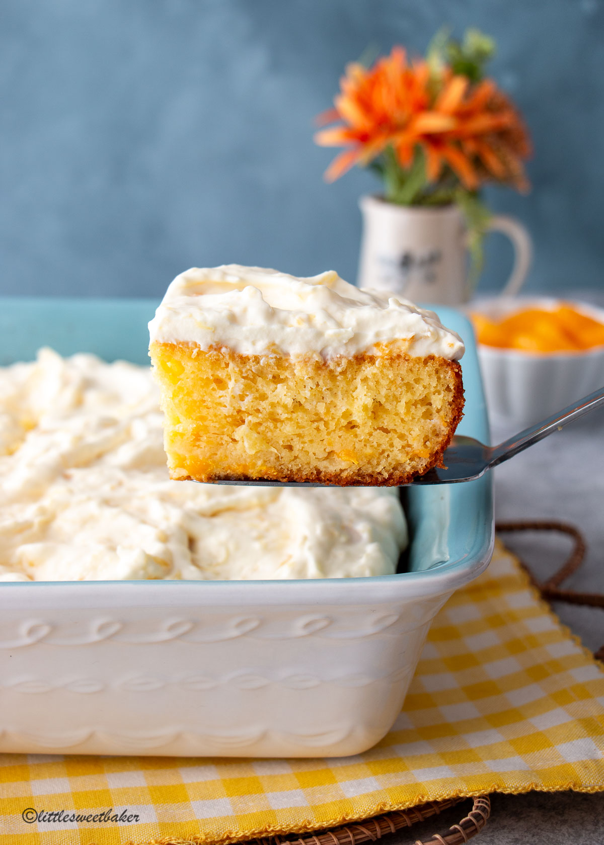 A slice of mandarin orange cake being lifted out of the pan.