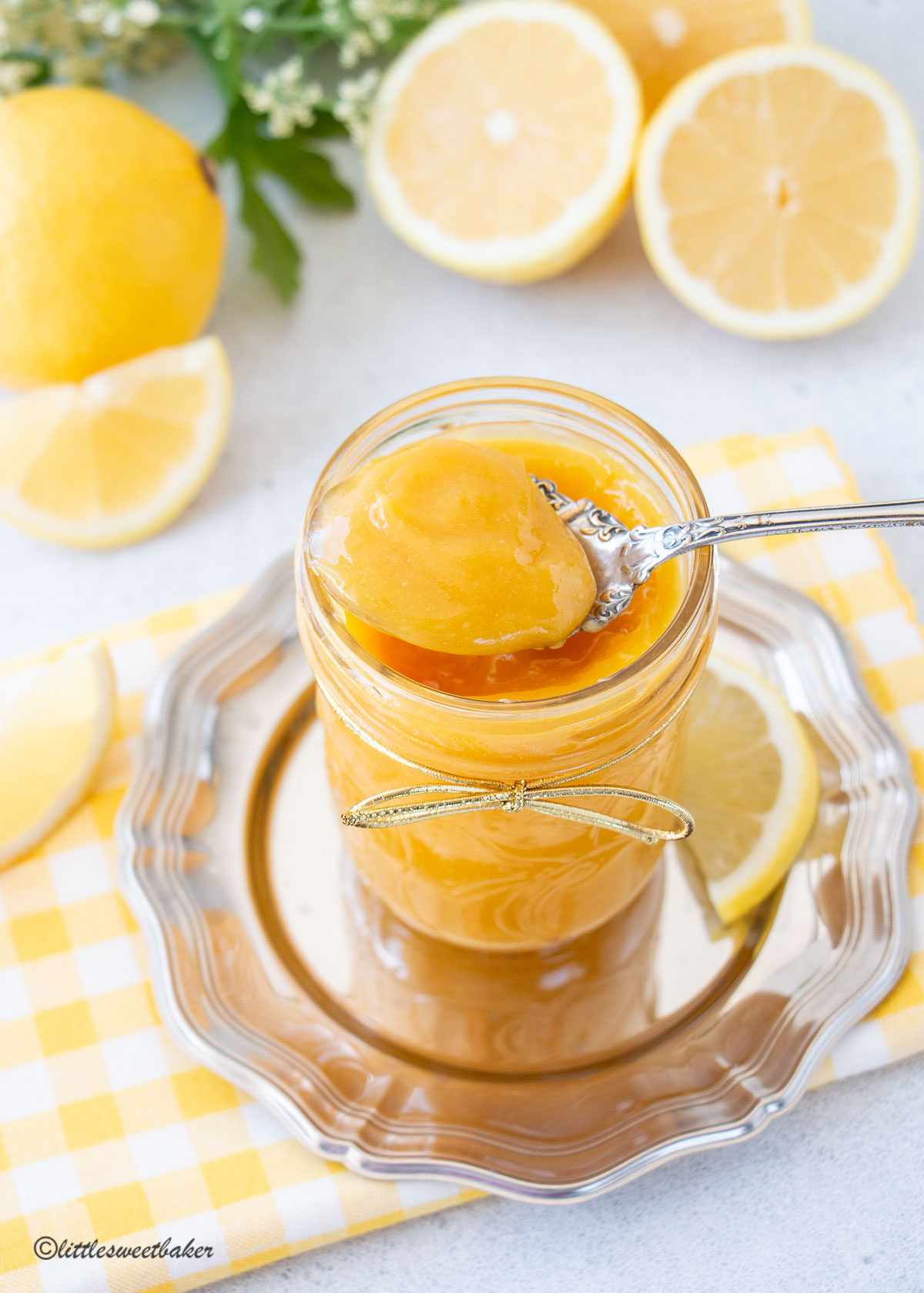 A jar of honey lemon curd with a spoonful resting on the jar.