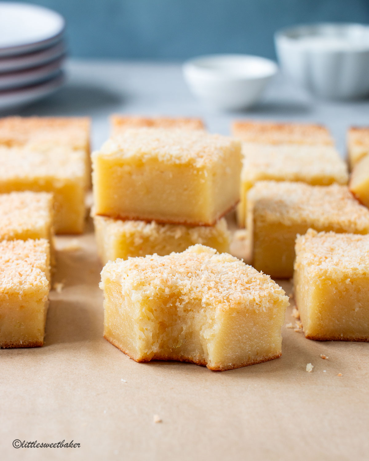 A slice of butter mochi cake with a bite taken out and other slices arranged in the back.