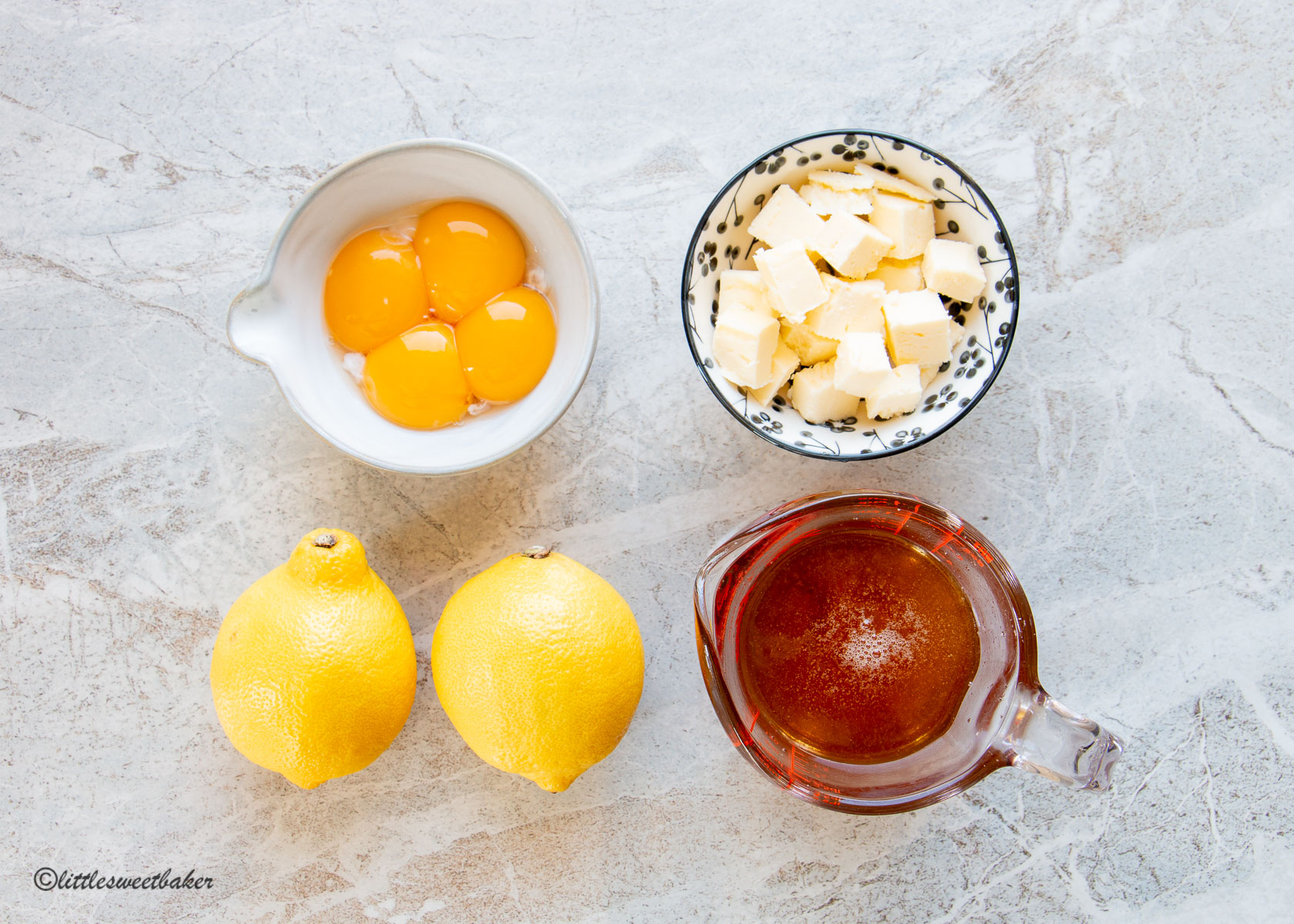 image of ingredients needed to make honey lemon curd: egg yolks, butter, lemons, and honey