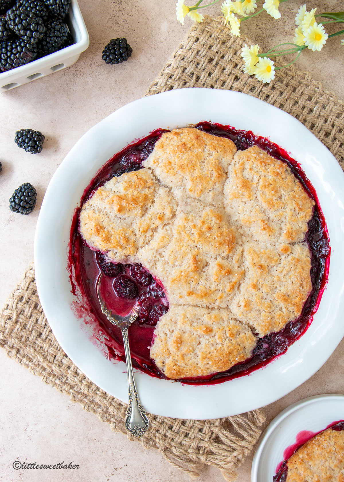A dish of blackberry cobbler with a portion missing.