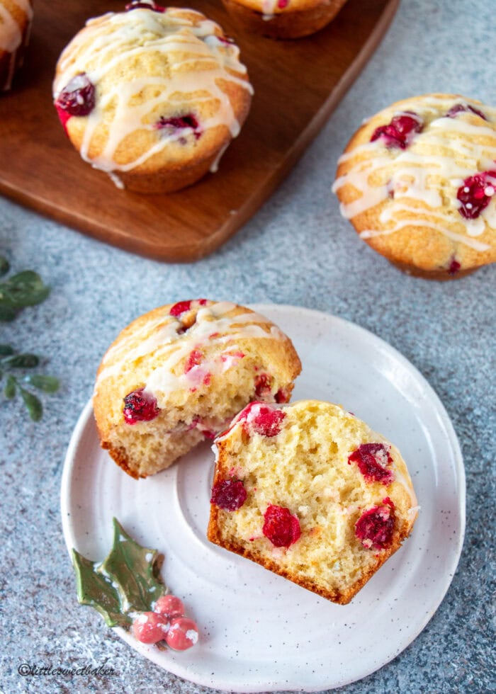 A cranberry orange muffin broken in half on a small plate.