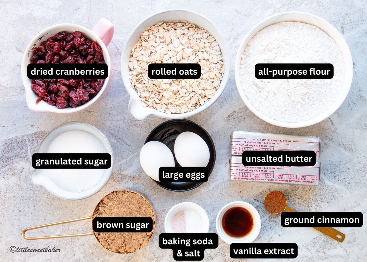 A labelled image of all the ingredients needed to make cranberry oatmeal cookies.