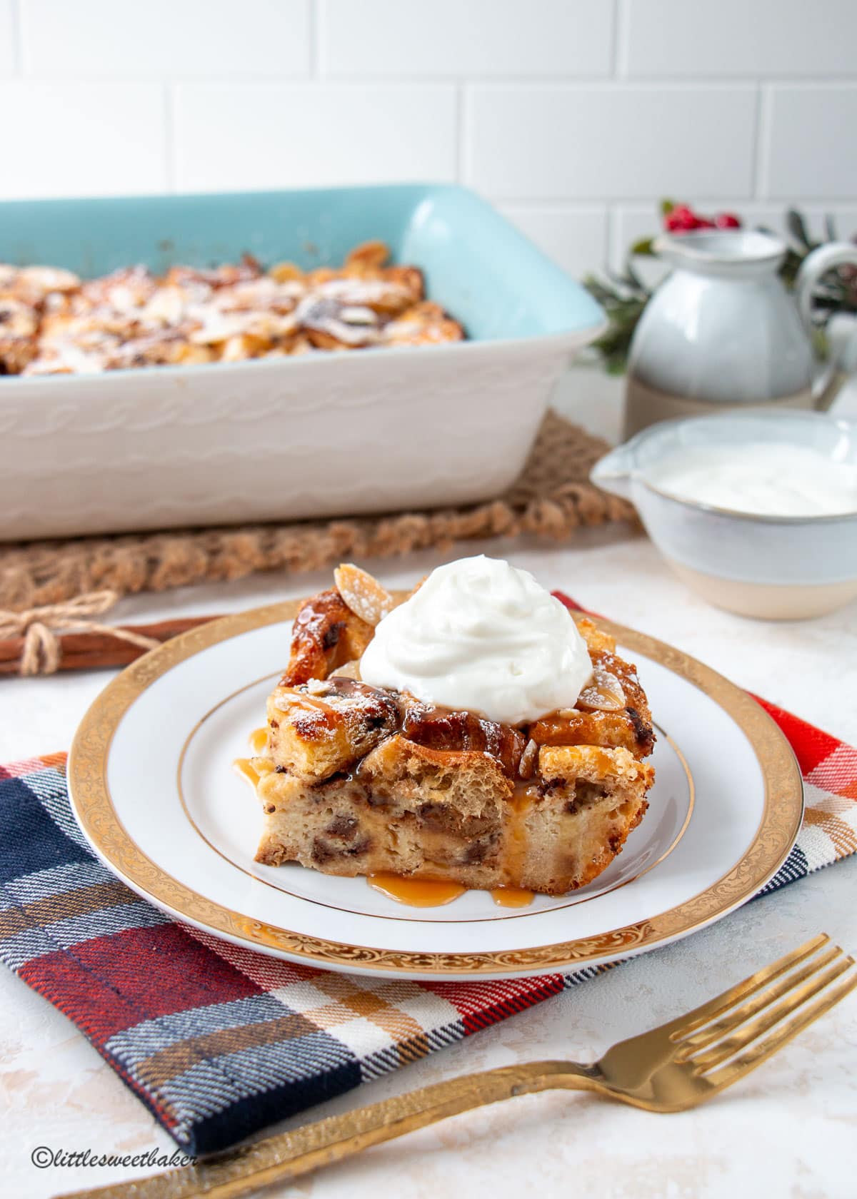 A slice of panettone bread pudding topped with caramel and whipped cream.