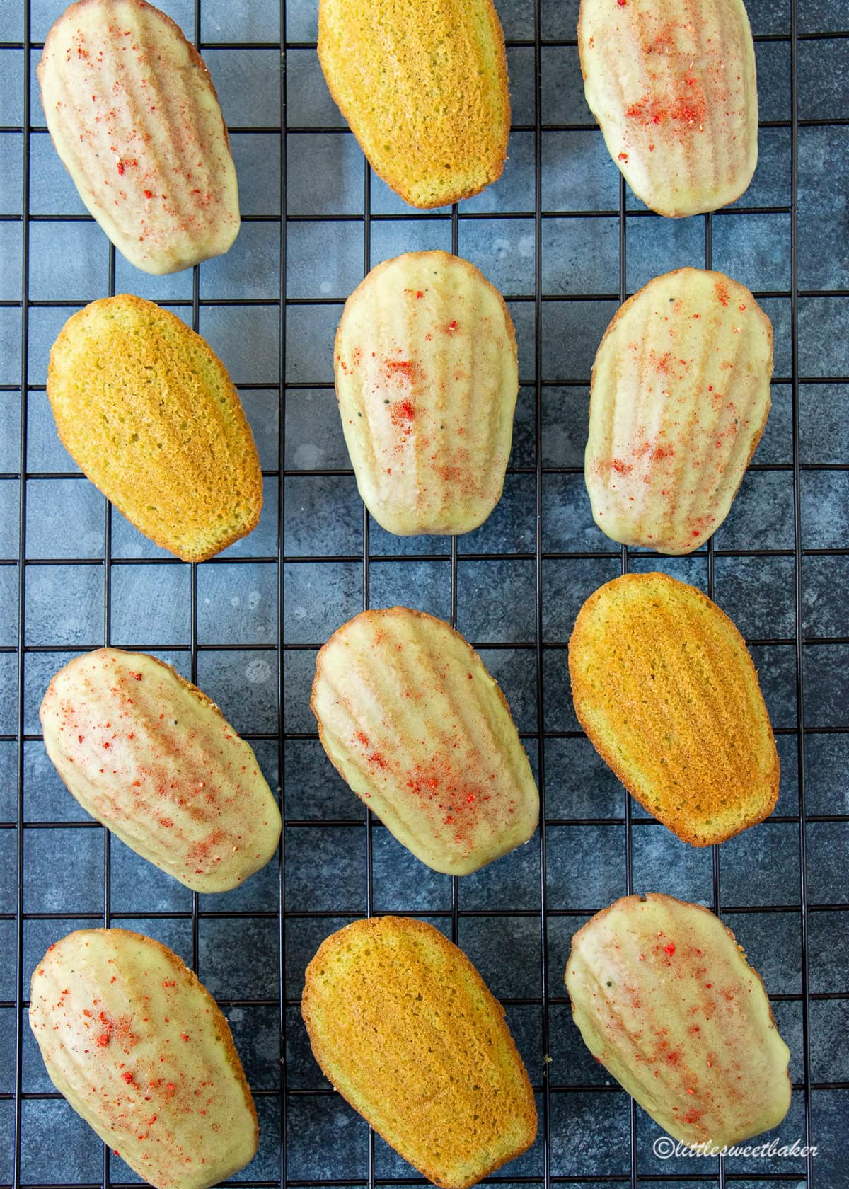 Glazed matcha madeleines on a cooling rack with some unglazed.