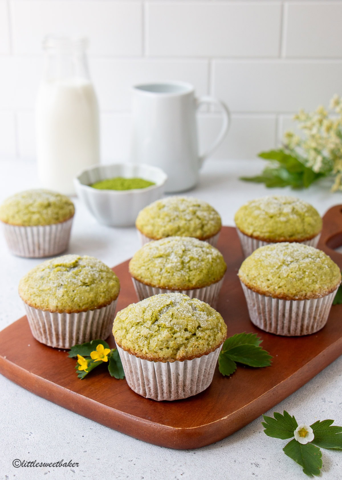 Matcha muffins on a wooden serving board.