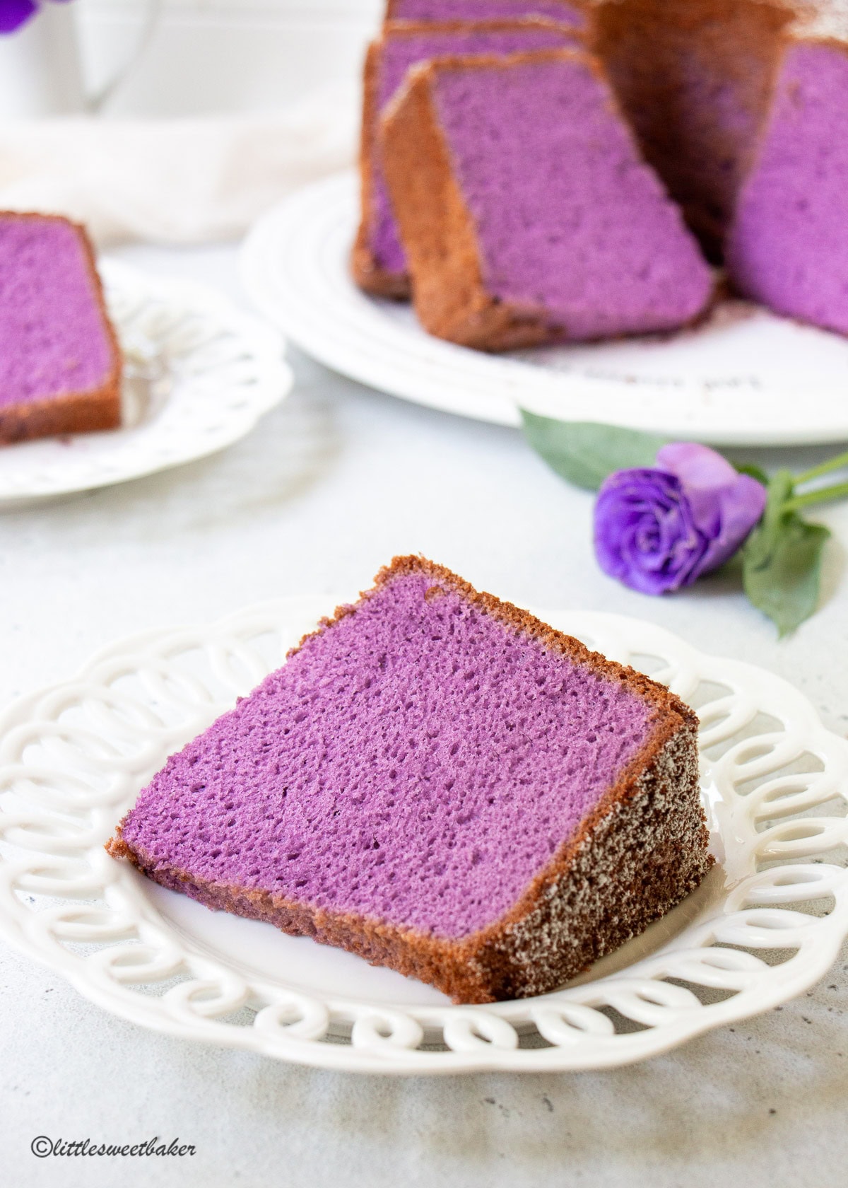 A slice of ube cake on a white dessert plate.