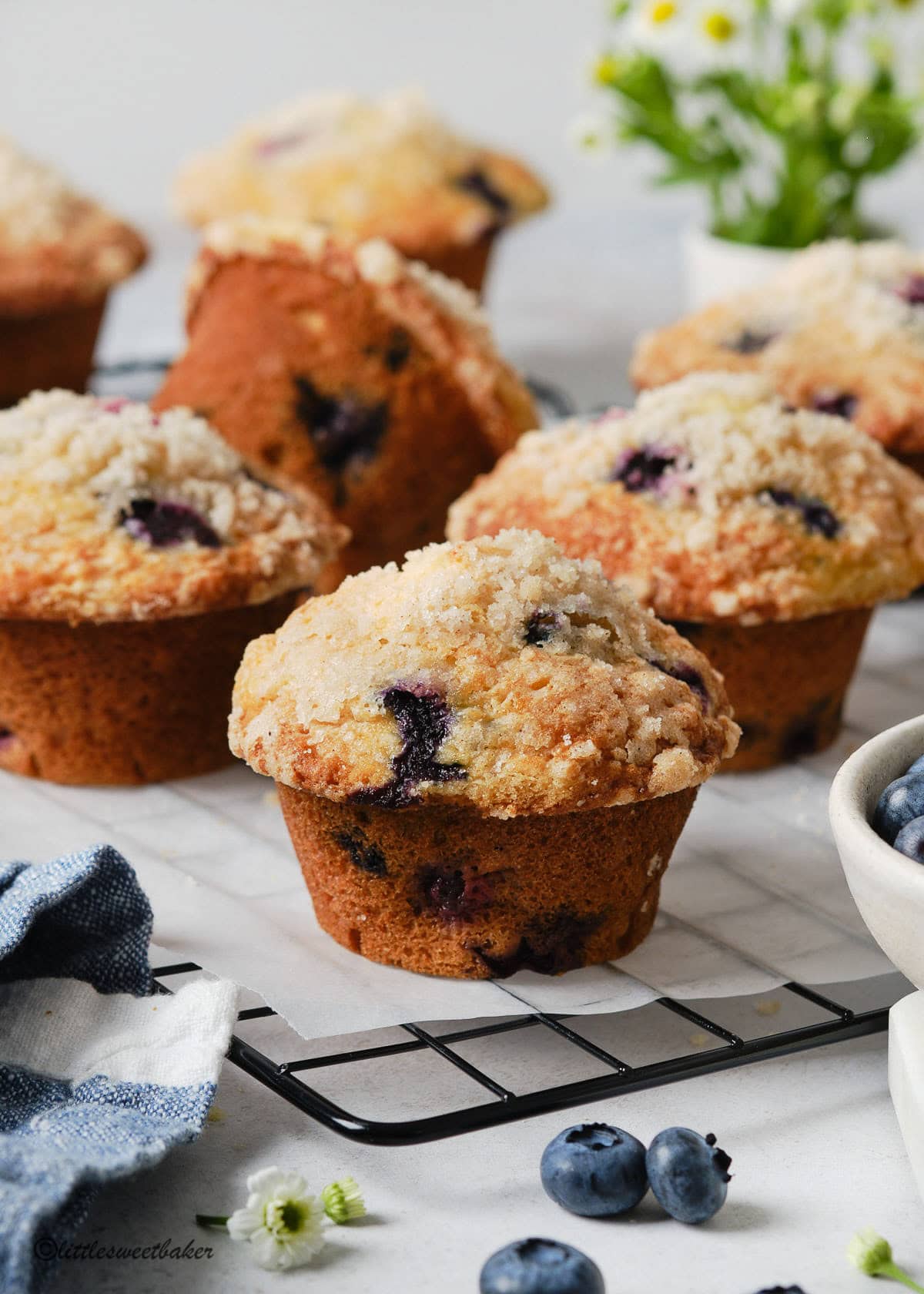 Blueberry Streusel Muffins on a cooling rack lined with parchment paper.